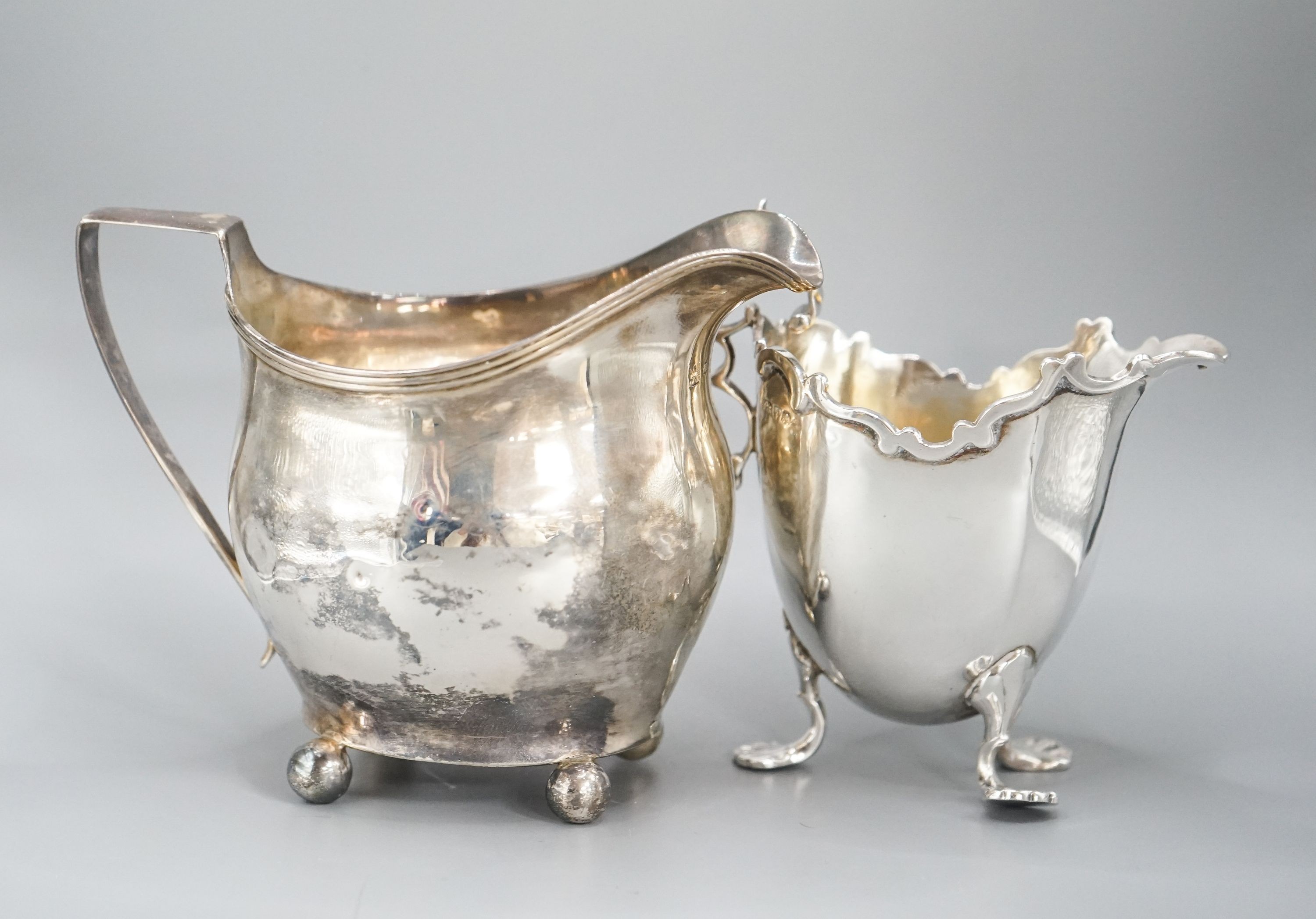 A Victorian repousse silver sugar bowl, a George III silver cream jug and a later silver cream jug